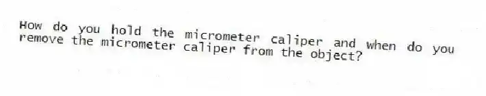 How do you hold the micrometer caliper and when do you remove the micrometer caliper from the object?