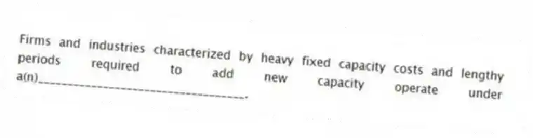 Firms and industries characterized by heavy fixed capacity costs and lengthy periods required to add new capacity operate under a(n)___________________________________.